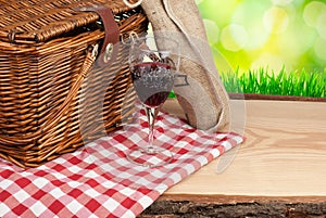 Picnic basket on the table and bottle of wine top angle