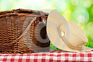 Picnic basket on the table and hat
