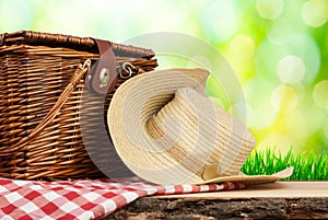 Picnic basket on the table with hat