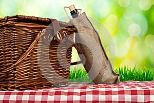 Picnic basket on the table and wine bottle
