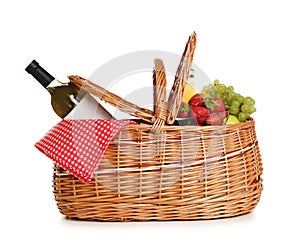 Picnic basket with wine and fruit on white