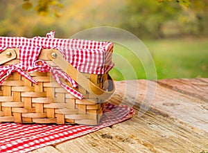 Picnic basket on a wooden table against the backdrop of autumn nature. Picnic, vacation, Thanksgiving, Harvest Day celebration,