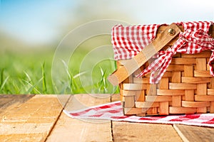 Picnic basket on a wooden table with a tablecloth. relaxing on a picnic, and enjoyable in nature, with space