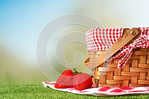 Picnic basket on a wooden table with a tablecloth and strawberries. relaxing on a picnic, and enjoyable in nature, with space