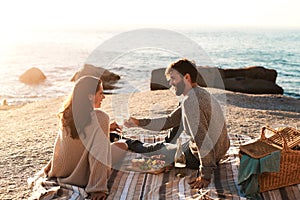 Picnic, beach and couple with champagne happy for relax, bonding and quality time on romantic date. Nature, dating and