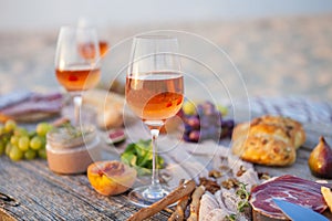 Picnic on the beach at sunset in boho style, food and drink conc