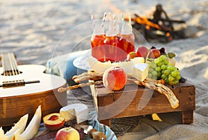Picnic on the beach at sunset with fruits and juices