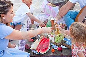 Picnic on the beach at sunset in the style boho, food and drink conception