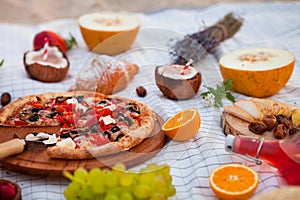 Picnic on the beach at sunset in the white plaid, food and drink