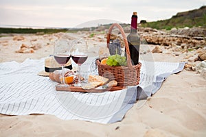 Picnic on the beach at sunset in the white plaid, food and drink