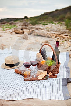 Picnic on the beach at sunset in the white plaid, food and drink