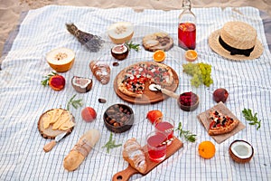 Picnic on the beach at sunset in the white plaid, food and drink