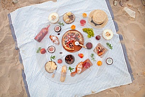 Picnic on the beach at sunset in the white plaid, food and drink