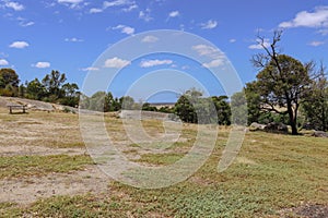 Picnic bench in a field amongst rocks in You Yangs Regional Park. Australia.