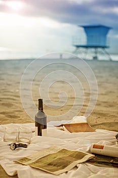 Picnic blanket on sandy beach at sunset