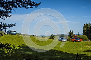 Picnic, cars parked in a clearing in the mountains on the green