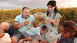 Picnic of caucasian couple with two kids in wheat field in slow motion