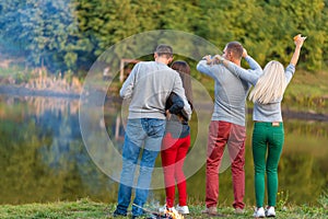 Picnic with friends in at lake near bonfire. Company friends having hike picnic nature background. Hikers relaxing during drink