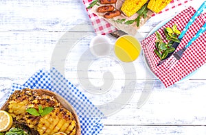 Picnic with grilled food. Sausages, pineapple, peaches and corn