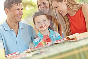 Picnic lunch in the park. Happy attractive family having a picnic in the park.