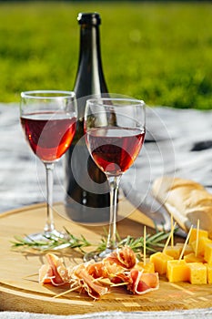 picnic in nature a light meal under wine, on a wooden background two glasses of red wine