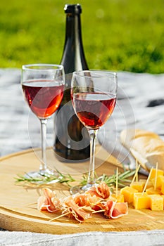 picnic in nature a light meal under wine, on a wooden background two glasses of red wine