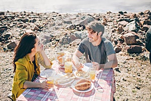 Picnic near the water. Happy family on a road trip in their car. Man and woman are traveling by the sea or the ocean or