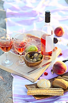 Picnic outdoor with rose wine fruits meat and cheese