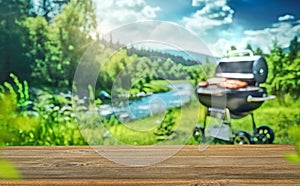 picnic outdoors with grill BBQ, wooden table, blurred background