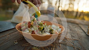 picnic outdoors in nature. woman cooking food outdoors. closeup female hands cutting eggs for salad in autumn forest at