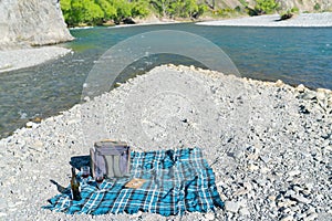 Picnic setting on stony river bed by fork in river