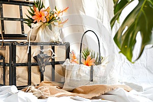 a picnic setup with a hamper and a bag full of tropical blossoms