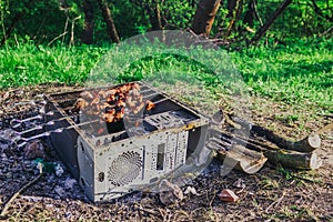 A picnic with a fire and a grill in the old computer case