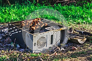 A picnic with a fire and a grill in the old computer case
