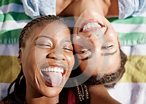 Picnic, summer and girl friends relaxing on a blanket outdoors, crazy tongue and having fun together. Black woman, smile