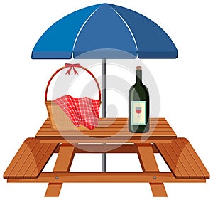 Picnic table with basket and bottle of wine under blue umbrella