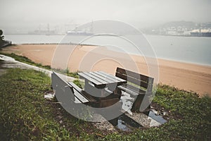 Picnic table and benches in a park on a rainy day