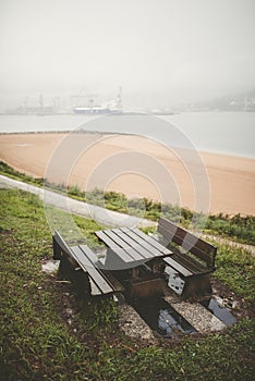 Picnic table and benches in a park on a rainy day