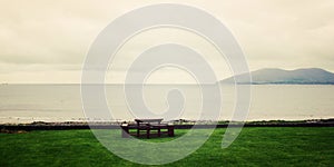 Picnic Table Benches and seascape in Waterville, County Kerry - vintage effect.