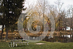 Picnic table by calm lake surrounded by colorful trees during the fall in Morris County, New Jersey