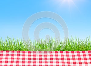 A Picnic table covered with checkered tablecloth