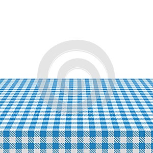 The picnic table is covered with a checkered tablecloth. White blue gingham textile. Clean surface with textile