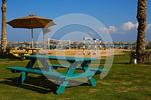Picnic table on the lawn against the backdrop of the beach