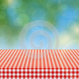 Picnic table with red checkered pattern of linen tablecloth and blurred nature background vector illustration