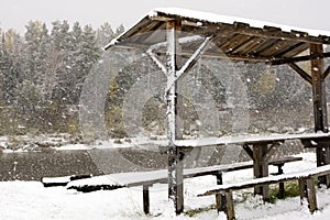 Picnic table beside a river. The snowfall on the river