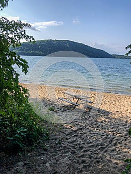 Picnic table on sandy beach by water