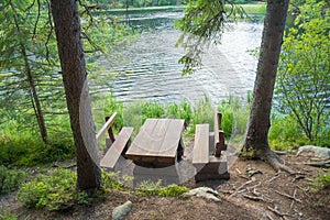 Picnic table seating in forest near lake