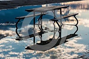 Picnic Table in Water with Reflected Sky