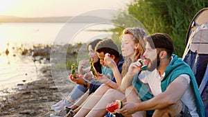 Picnic time for a charismatic group of friends multiracial they enjoy the time together eating a tasty watermelon