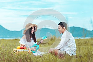 Picnic time. Young couple having fun with guitar on picnic in the park. Love and tenderness, dating, romance, lifestyle concept